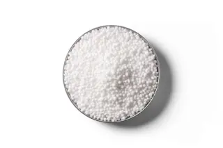 White urea fertiliser granules in a round dish